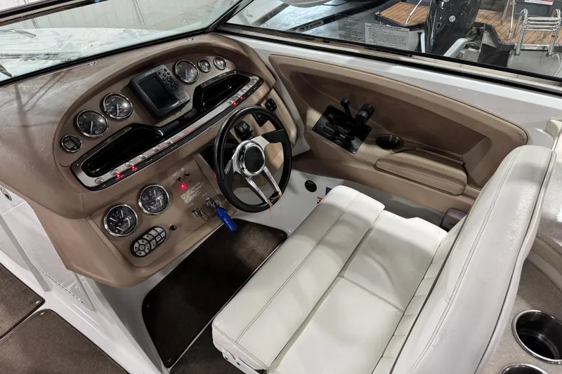 Slide: The Image of 2007 Cobalt 302 boat cockpit with steering wheel, gauges, and beige seating. - 9