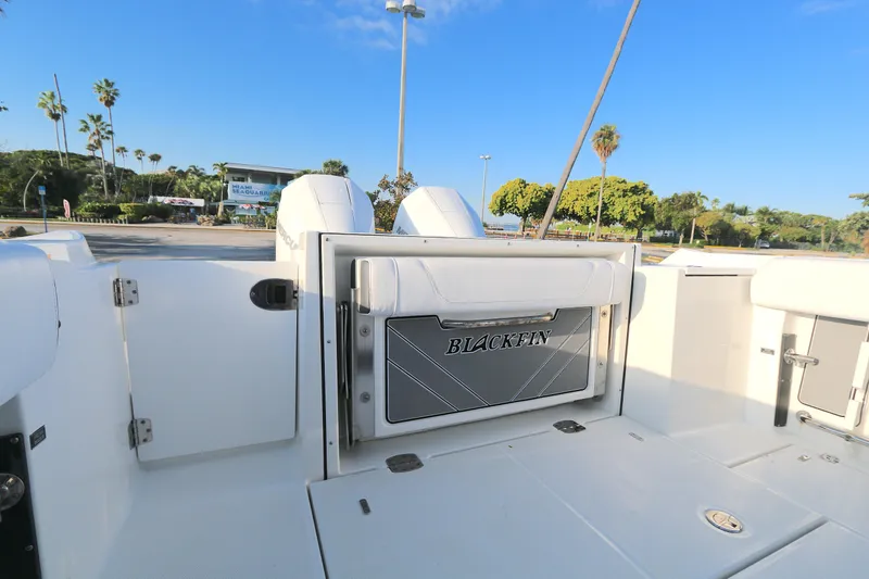 Slide: The Image of 2021 BLACWATER 252CC boat interior with Blackfin branding, parked near lush greenery. - 10