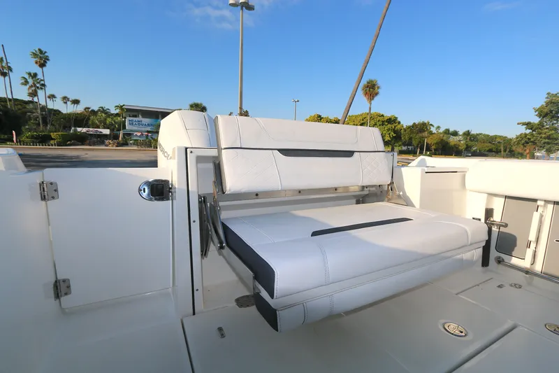 Slide: The Image of 2021 BLACWATER 252CC boat with white seating, outdoor setting, clear blue sky. - 11
