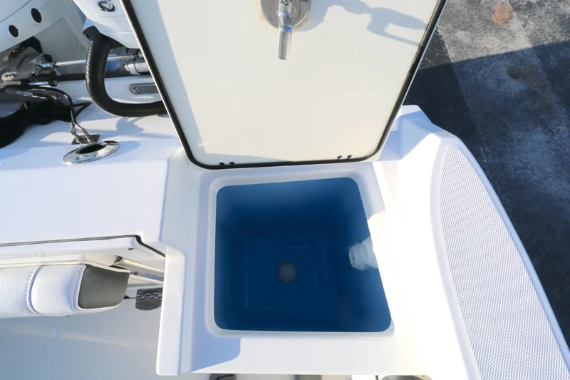 Slide: The Image of Open storage compartment on 2021 BLACWATER 252CC boat, featuring a blue interior. - 14
