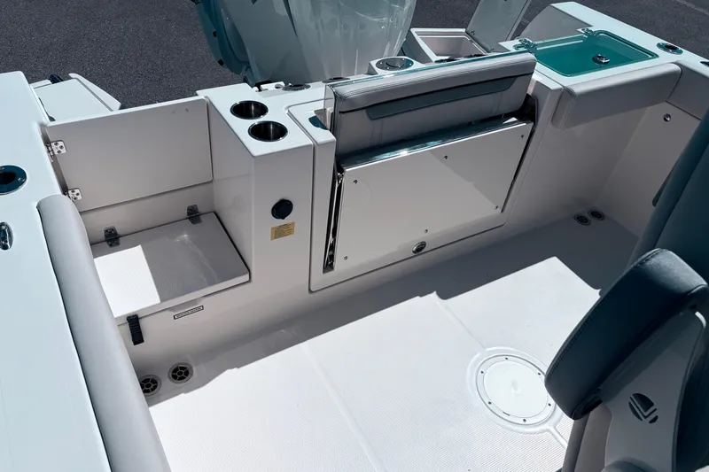 Slide: The Image of 2026 Sailfish 252 CC boat interior with seating, cup holders, and storage compartments. - 14