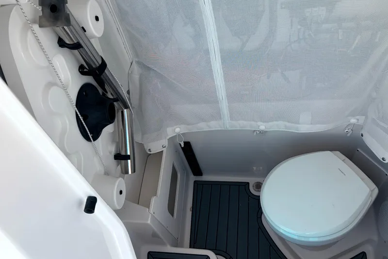 Slide: The Image of Interior of 2026 Sailfish 252 CC boat featuring a compact marine toilet. - 24