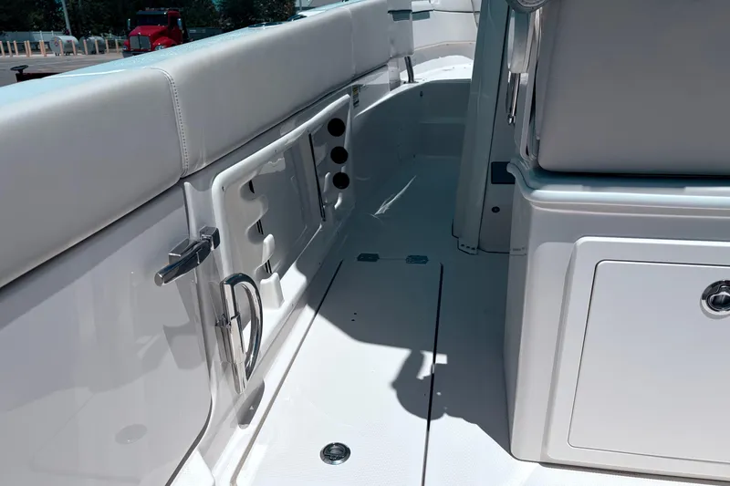 Slide: The Image of Interior view of 2026 Sailfish 252 CC boat, featuring sleek white seating and storage compartments. - 30