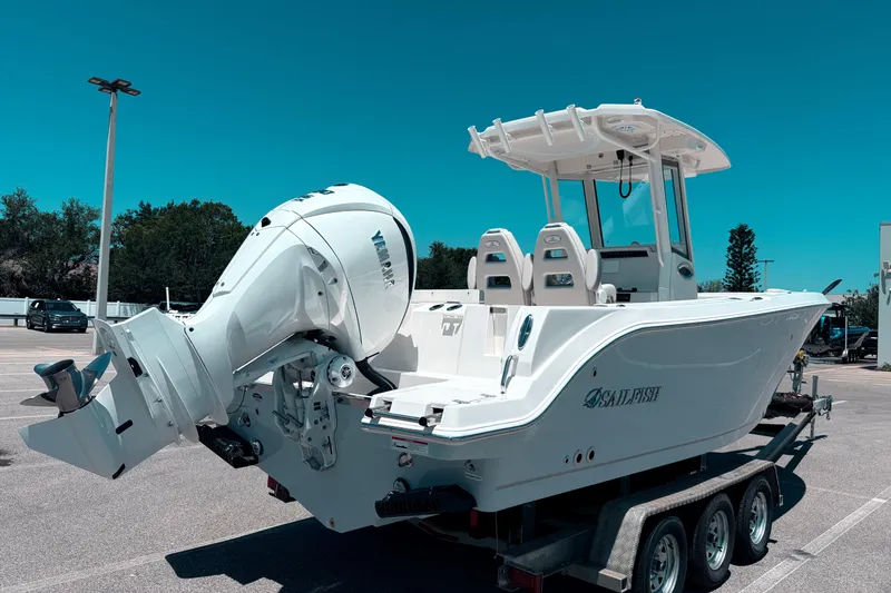 Slide: The Image of 2026 Sailfish 252 CC boat on trailer, featuring powerful outboard motor, under clear blue sky. - 5