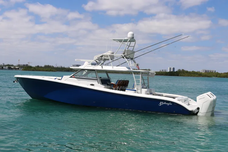 The Image of 2021 Yellowfin 54 Offshore boat on calm water, blue hull, clear sky background. - 0