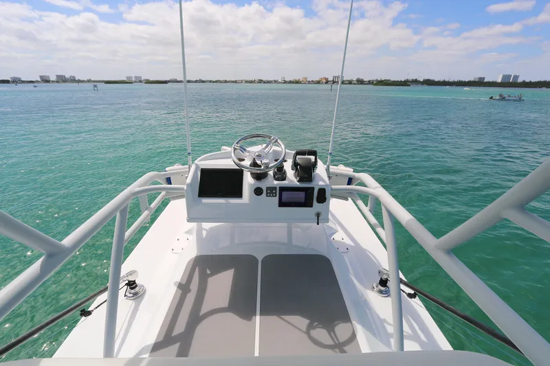 Slide: The Image of 2021 Yellowfin 54 Offshore boat helm overlooking turquoise waters and distant shoreline. - 14