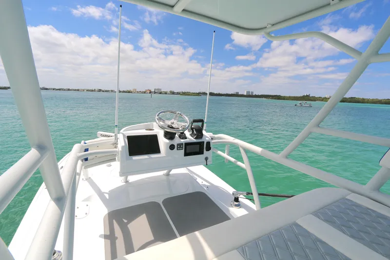 Slide: The Image of 2021 Yellowfin 54 Offshore boat helm with ocean view, featuring modern navigation equipment. - 15
