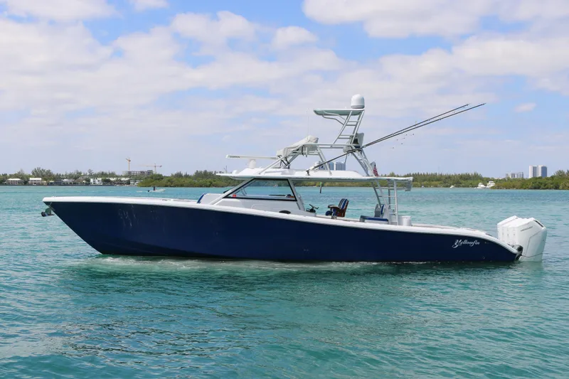 Slide: The Image of 2021 Yellowfin 54 Offshore boat on clear blue water under a partly cloudy sky. - 27