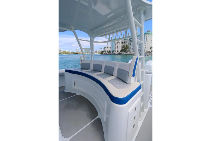 Slide: The Image of 2021 Yellowfin 54 Offshore boat with cushioned seating, docked near waterfront buildings. - 9