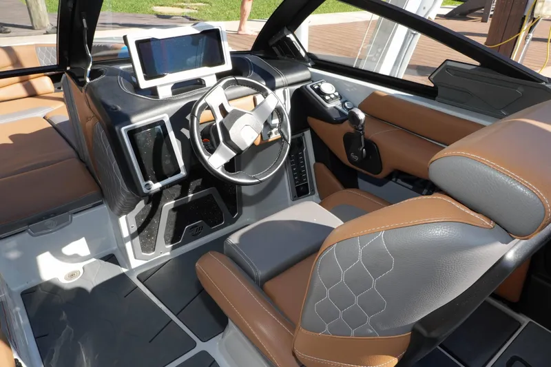 Slide: The Image of 2020 Malibu M240 boat interior with modern dashboard and leather seating. - 17