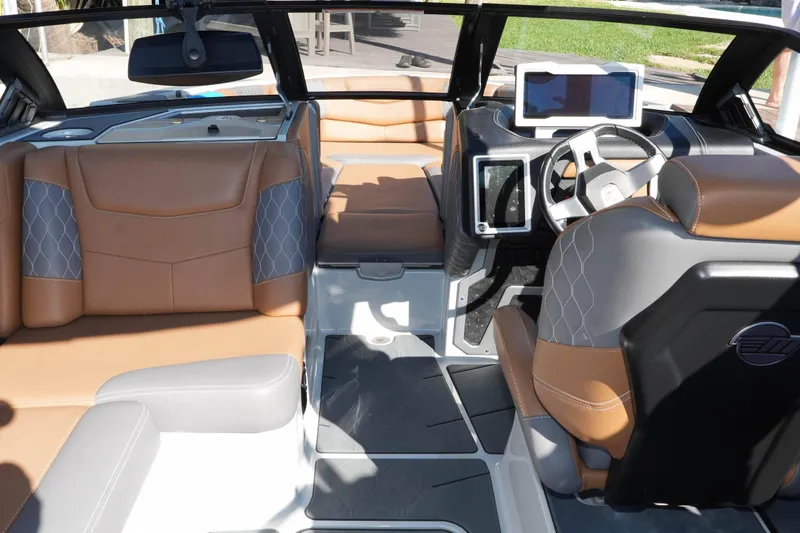 Slide: The Image of 2020 Malibu M240 boat interior with luxurious seating and modern dashboard design. - 18