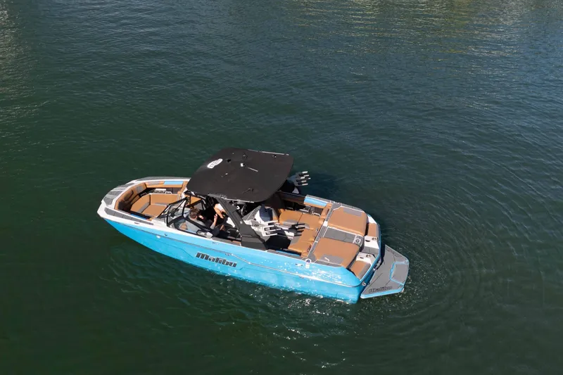 Slide: The Image of 2020 Malibu M240 boat on calm water, featuring sleek design and spacious seating. - 2