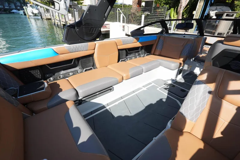 Slide: The Image of 2020 Malibu M240 boat interior with luxurious tan and gray seating. - 26