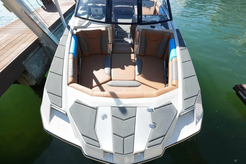 Slide: The Image of 2020 Malibu M240 boat with luxurious seating, docked on clear water. - 32