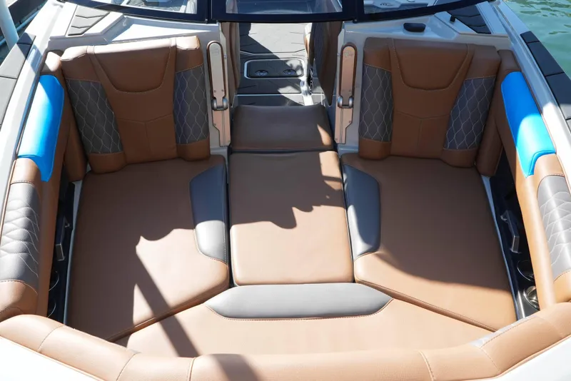 Slide: The Image of 2020 Malibu M240 boat interior with brown and blue cushioned seating. - 8