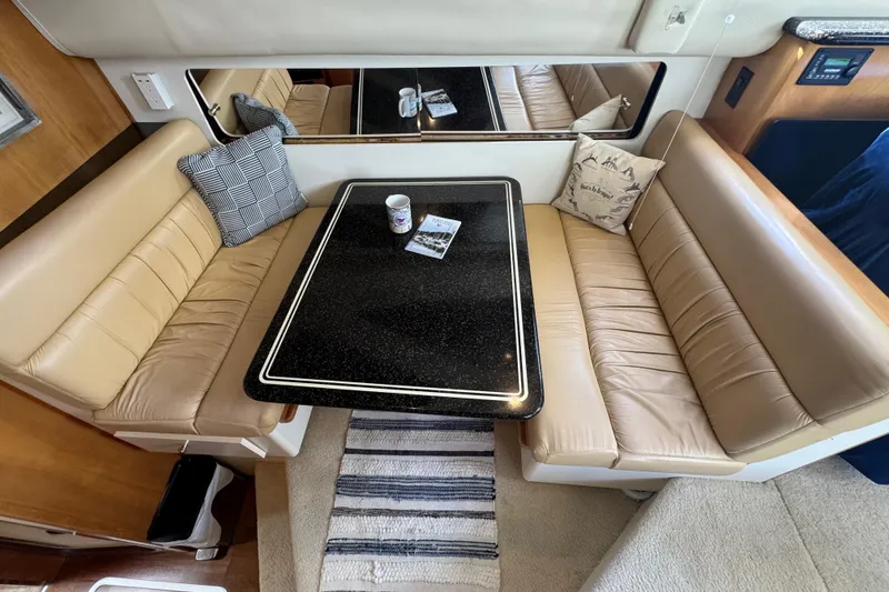 Slide: The Image of Interior of 2001 Carver 356 Motor Yacht with beige seating and black table. - 10