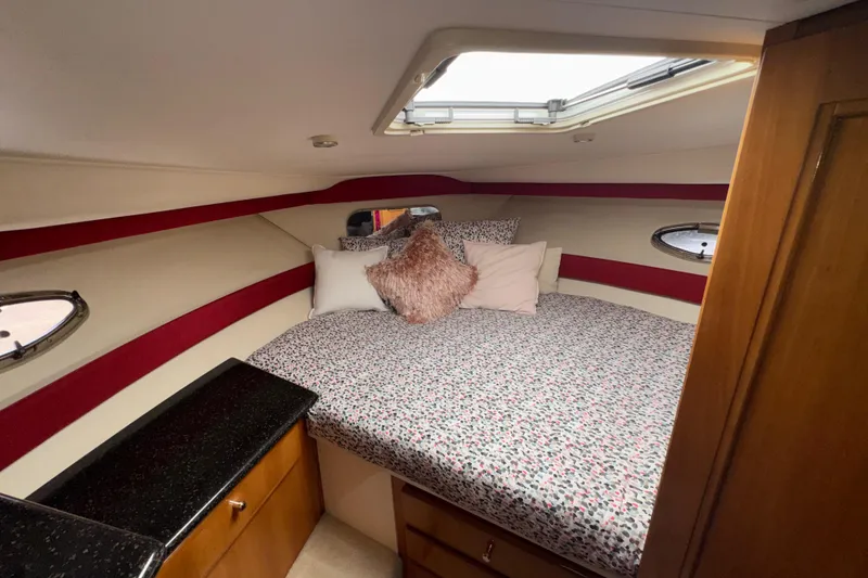 Slide: The Image of Cozy bedroom in 2001 Carver 356 Motor Yacht with patterned bedding and porthole windows. - 13
