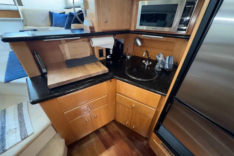 Slide: The Image of Compact kitchen area in a 2001 Carver 356 Motor Yacht with sink, microwave, and cutting board. - 14