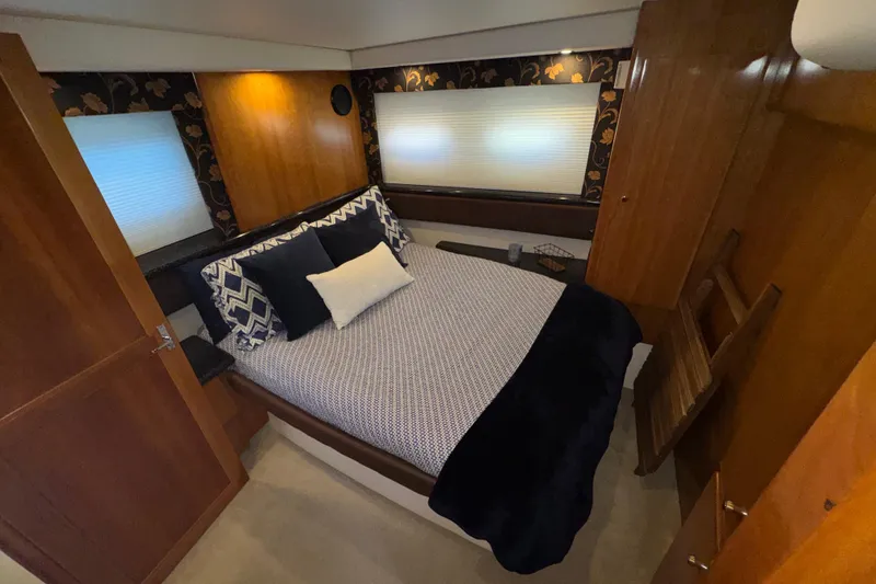 Slide: The Image of Luxurious bedroom interior of 2001 Carver 356 Motor Yacht with elegant bedding and wood paneling. - 19