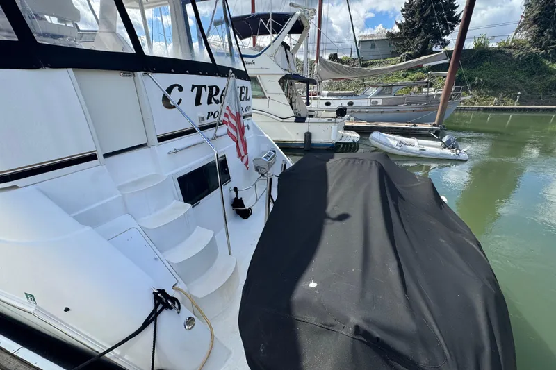Slide: The Image of 2001 Carver 356 Motor Yacht docked with covered equipment and American flag. - 2