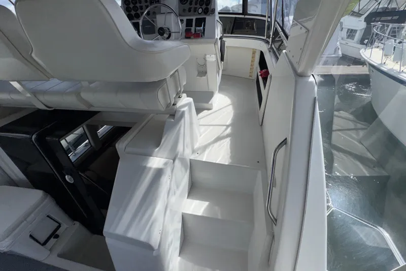 Slide: The Image of 2001 Carver 356 Motor Yacht interior with helm, white seating, and steps. - 29