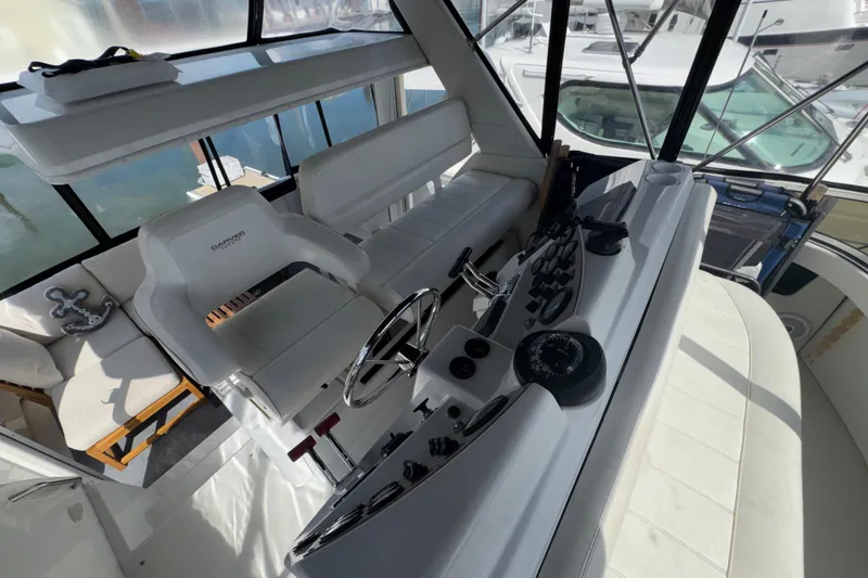 Slide: The Image of Interior view of 2001 Carver 356 Motor Yacht helm with white seating and control panel. - 33