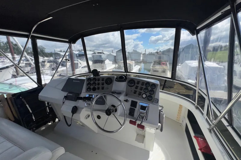 Slide: The Image of 2001 Carver 356 Motor Yacht helm with navigation controls and marina view. - 37