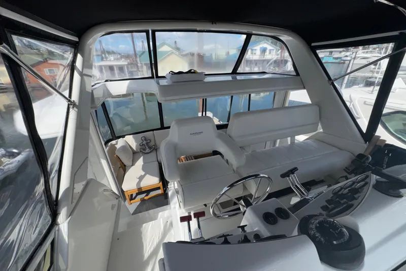 Slide: The Image of Interior view of 2001 Carver 356 Motor Yacht helm with white seating and controls. - 38