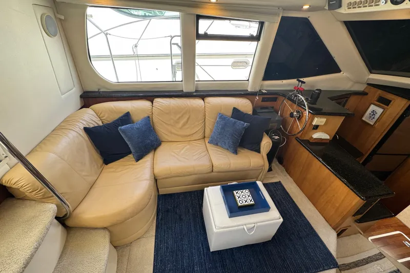 Slide: The Image of Interior of 2001 Carver 356 Motor Yacht with beige leather seating and blue accents. - 5