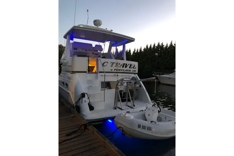 Slide: The Image of 2001 Carver 356 Motor Yacht docked at sunset with blue accent lighting. - 58