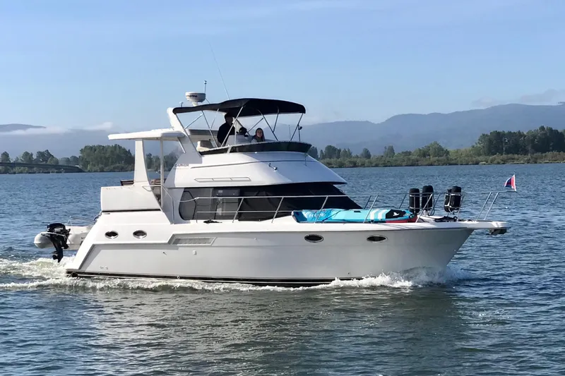 Slide: The Image of 2001 Carver 356 Motor Yacht cruising on a scenic lake with mountains in the background. - 60