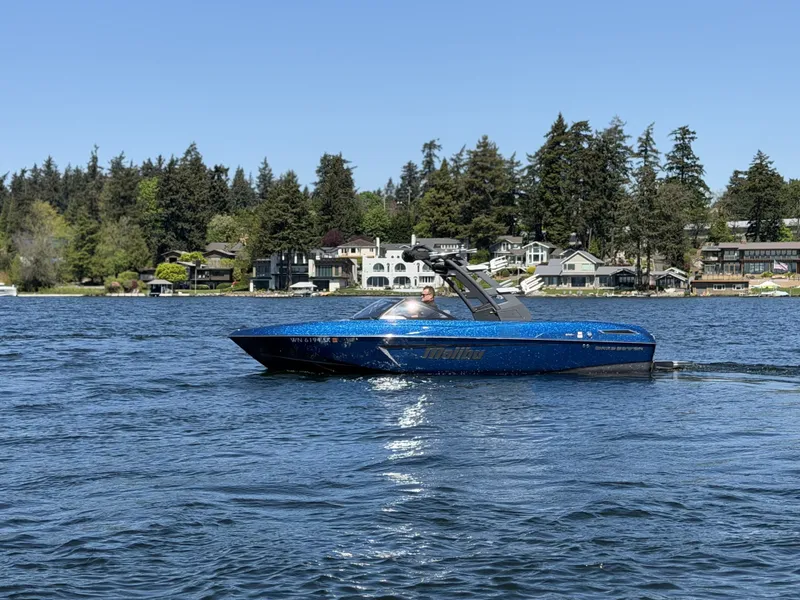 The Image of 2017 Malibu Wakesetter 23 LSV on a calm lake with houses in background. - 1