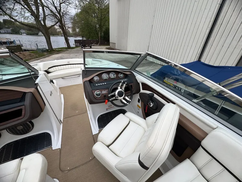 Slide: The Image of Interior of a 2014 Cobalt A25 boat with white leather and steering console. - 6