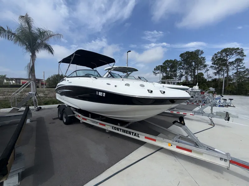Slide: The Image of 2020 Hurricane 2400 SD boat on trailer, palm trees in background. - 10