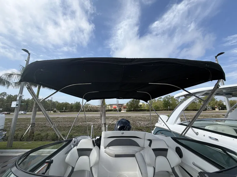 Slide: The Image of 2020 Hurricane 2400 SD boat with canopy, blue sky. - 12