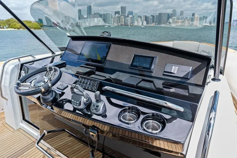 Slide: The Image of Helm of 2021 Pardo 43 yacht with modern controls and city skyline view. - 10