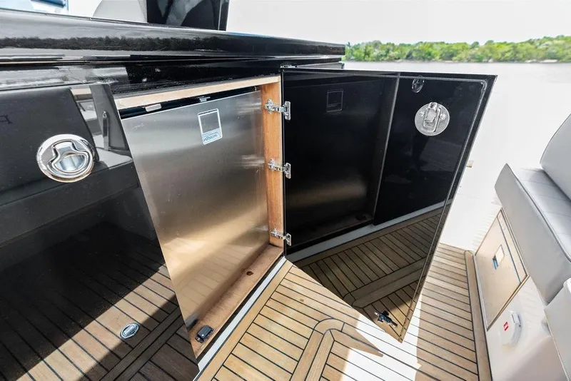 Slide: The Image of Open storage compartment on 2021 Pardo 43 yacht with sleek black finish and wooden flooring. - 14