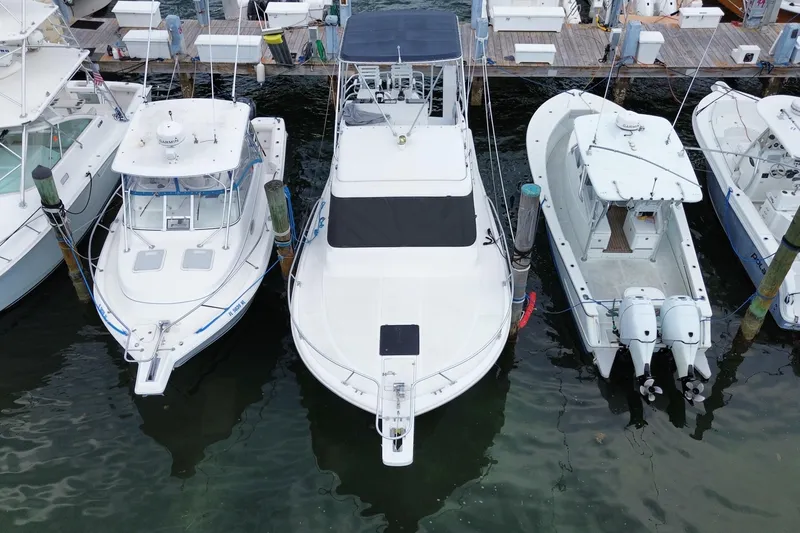 Slide: The Image of 1994 Luhrs 32 Convertible boat docked among other vessels at a marina. - 11