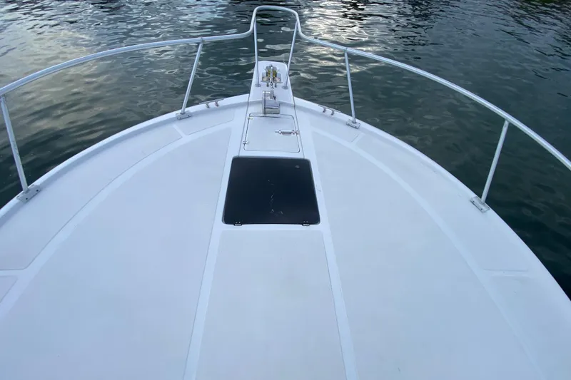 Slide: The Image of Bow view of a 1994 Luhrs 32 Convertible boat on calm water. - 16