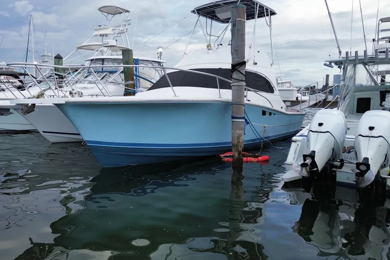 Slide: The Image of 1994 Luhrs 32 Convertible boat docked in a marina, featuring a light blue hull. - 2