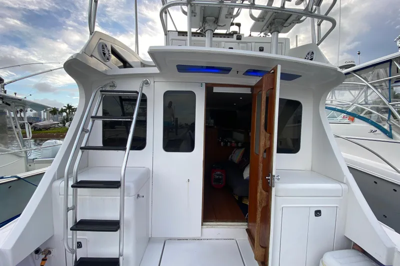 Slide: The Image of 1994 Luhrs 32 Convertible boat with open cabin door and ladder, docked at marina. - 20