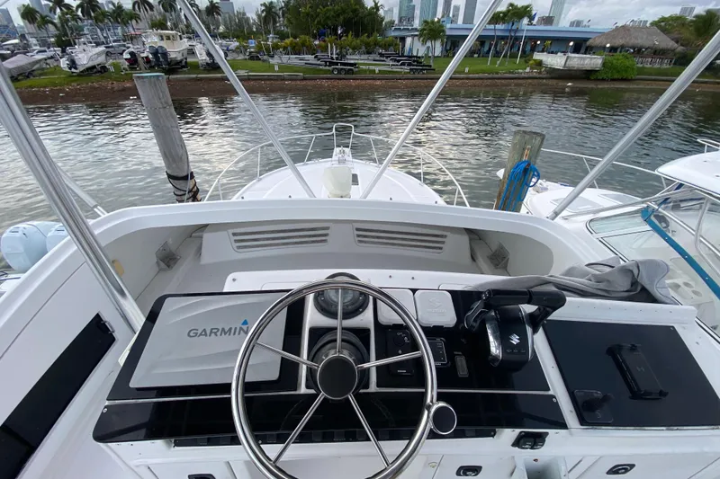 Slide: The Image of Helm of 1994 Luhrs 32 Convertible boat with Garmin navigation system, docked by the water. - 21