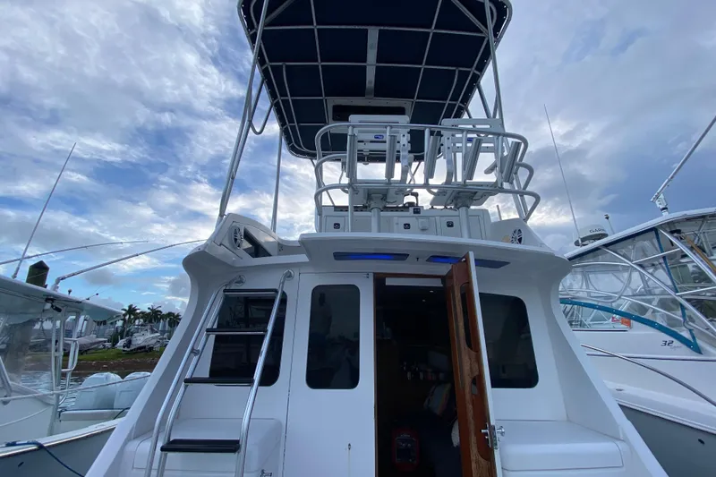 Slide: The Image of 1994 Luhrs 32 Convertible boat with upper deck and open cabin door. - 25