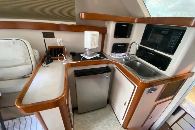 Slide: The Image of 1994 Luhrs 32 Convertible yacht interior with kitchenette, sink, and mini fridge. - 29