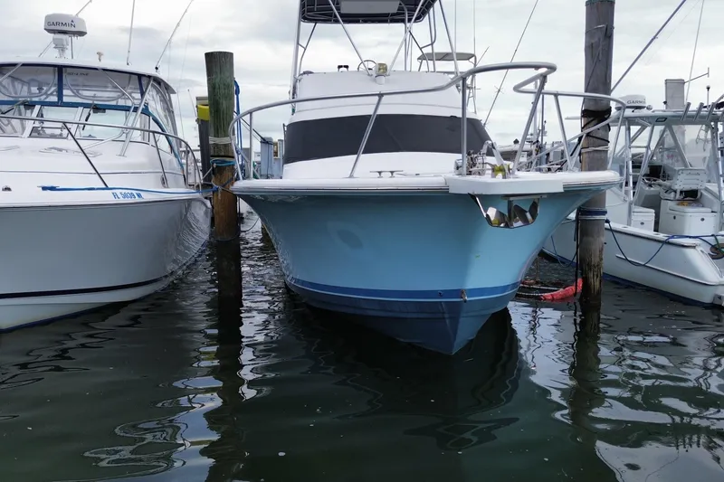 Slide: The Image of 1994 Luhrs 32 Convertible boat docked between two other vessels. - 3