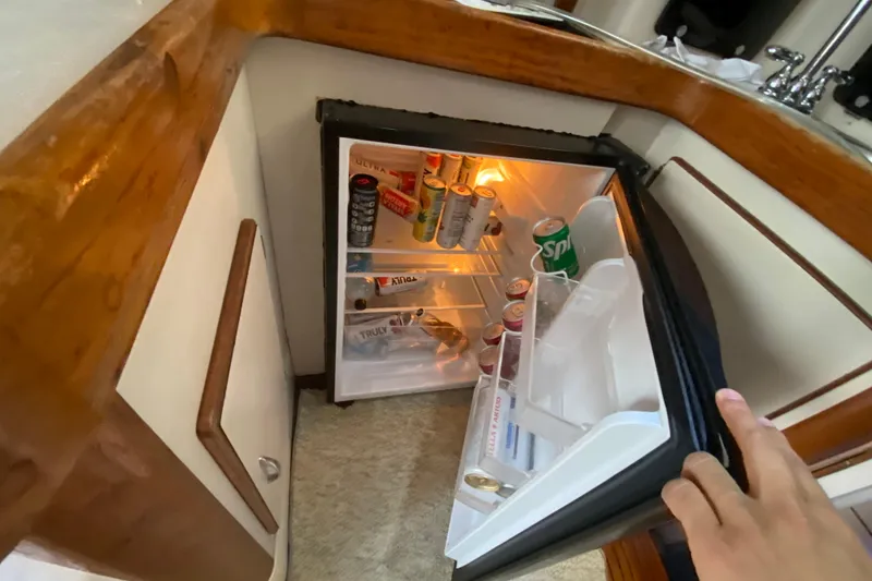 Slide: The Image of Mini fridge stocked with drinks inside a 1994 Luhrs 32 Convertible boat. - 32