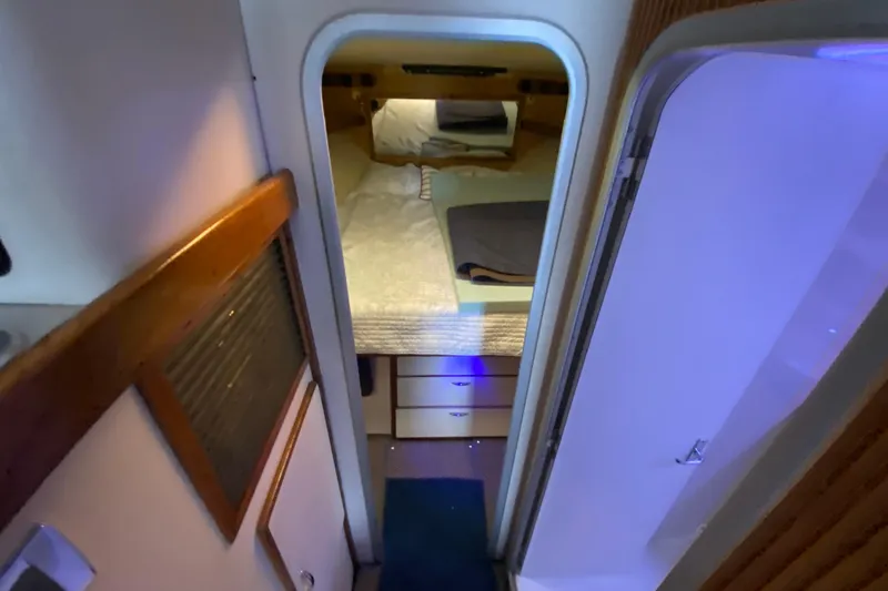 Slide: The Image of 1994 Luhrs 32 Convertible cabin interior with bed and storage drawers. - 34