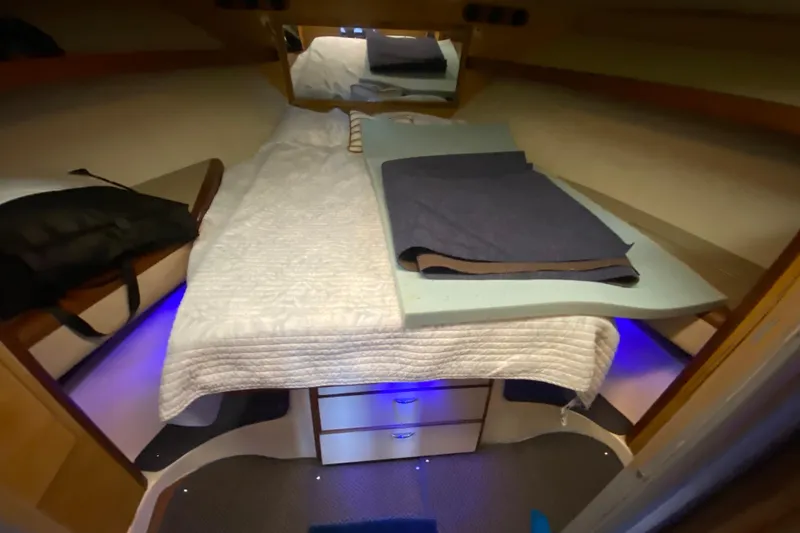 Slide: The Image of 1994 Luhrs 32 Convertible cabin interior with bed, storage, and ambient lighting. - 37