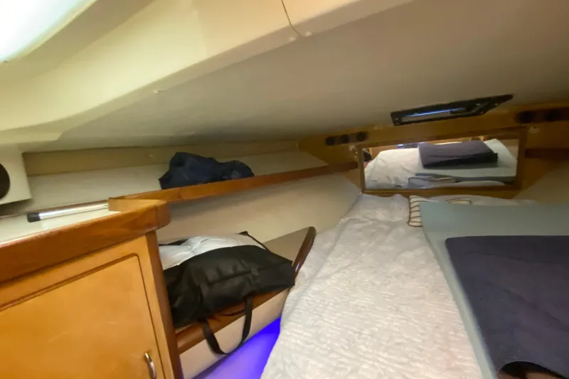 Slide: The Image of Cozy cabin interior of 1994 Luhrs 32 Convertible boat with bedding and storage. - 39