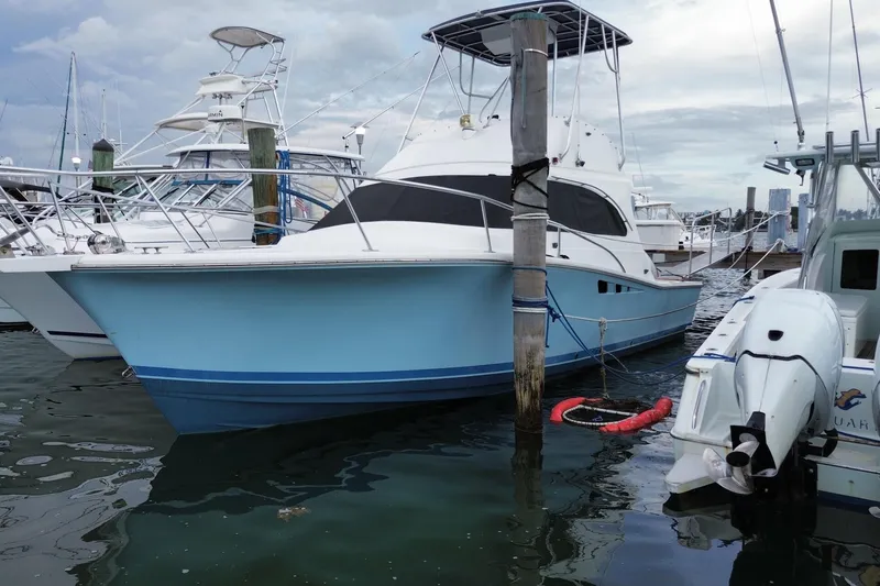 Slide: The Image of 1994 Luhrs 32 Convertible boat docked at marina, featuring a sleek blue hull design. - 4